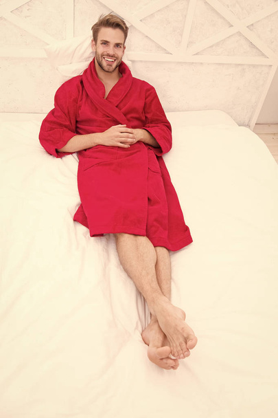 Guy in bathrobe relaxing. Maintaining consistent circadian rhythm essential for general health. Man handsome guy relaxing in bed. Relaxing before fall asleep. Get enough amount of sleep every night - Photo, Image