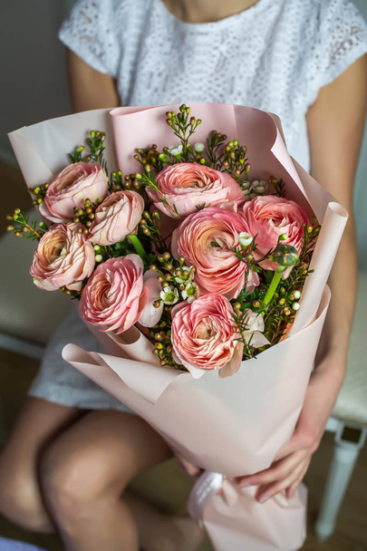 Ein Mädchen in weißem Kleid hält einen Strauß schöner Rosen in der Hand. Kein Gesicht. - Foto, Bild