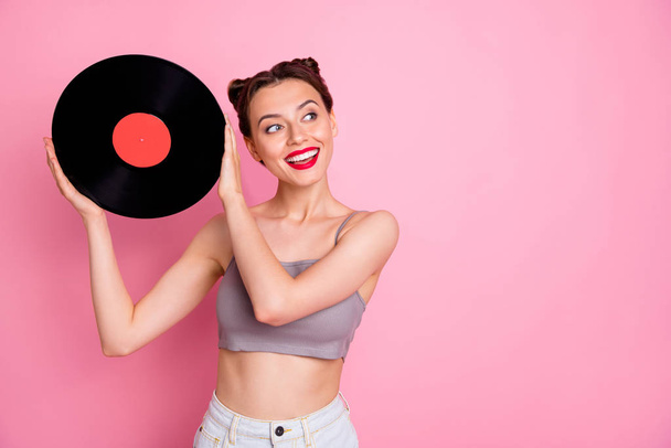 Portrait of lovely cute girl music lover hold vinyl plate gramophone disc want have retro party wear casual style clothing isolated over pink color background - Foto, immagini