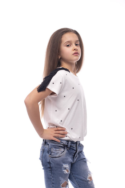 Halblanges Porträt eines jungen Mädchens, das Jeans und ein weißes T - Foto, Bild
