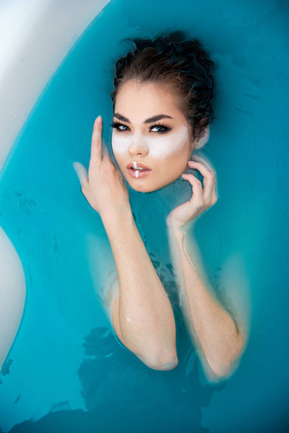 fashion beautiful girl posing in colorful bath water  - Foto, afbeelding