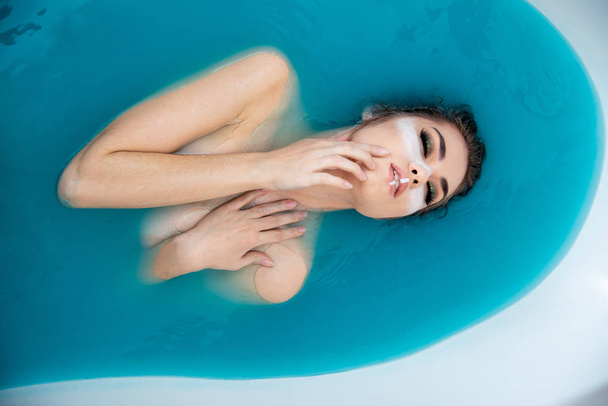 fashion beautiful girl posing in colorful bath water  - Fotó, kép