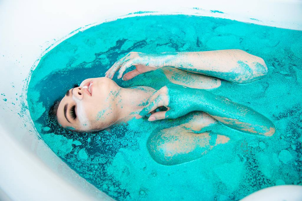 fashion beautiful girl posing in colorful bath water  - Photo, image