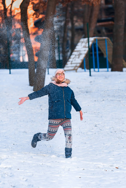 Happy teenage girl throwing snowballs and jumping - Zdjęcie, obraz