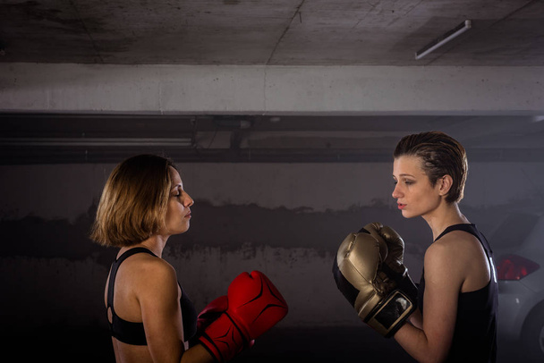 Крупним планом зображення двох жінок-боксерів з захисним обладнанням, що здійснює удари і бокс
 - Фото, зображення