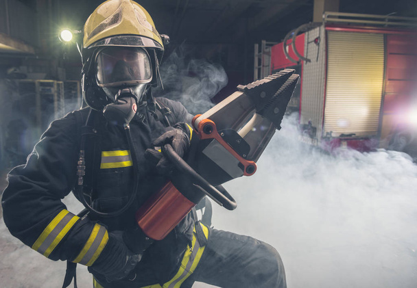 Портрет смелого пожарного, уверенно стоящего в полном обмундировании  - Фото, изображение