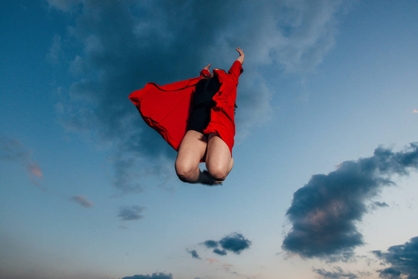 Liikkumisvapaus. Ammuttu melko onnellinen nuori nainen hyppää korkealle taivaalle
 - Valokuva, kuva