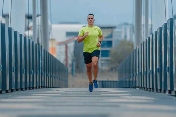 Атлетик старше 40 лет, одетый в спортивную форму во время бега - Фото, изображение