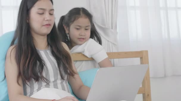 Asian girls and sisters are using laptops, computers and tablets to connect to the cyber world. The little girl rested at home using the internet. - Filmati, video