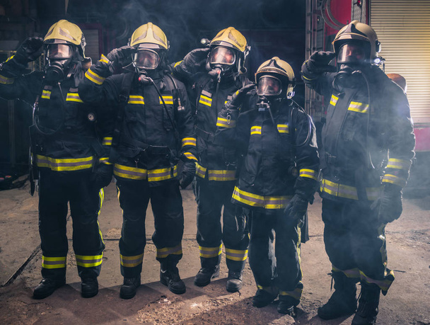 消火器の真ん中に立つ消防士のチーム - 写真・画像