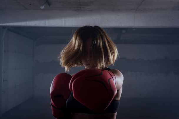 Siluetti muotokuva nuorten houkutteleva kunto nainen käyttää lävistys punaisella nyrkkeilyhanskat autotallissa - Valokuva, kuva