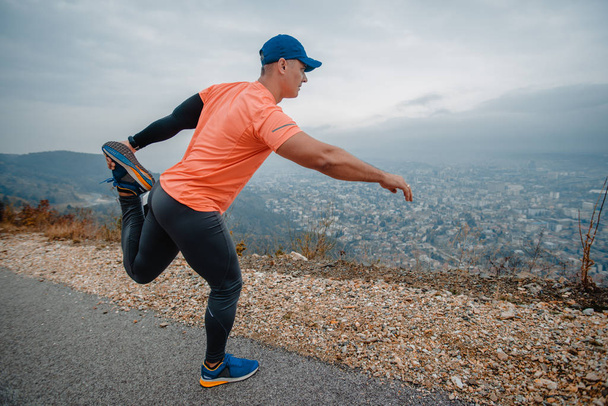 Hombre maduro muscular de más de 40 años en ropa deportiva que se extiende al aire libre
 - Foto, Imagen