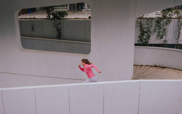 Спортсменка-молода жінка займається спортом у міському районі міста
 - Фото, зображення
