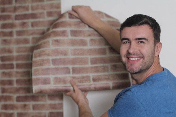 Man using brick wall style wallpaper - 写真・画像