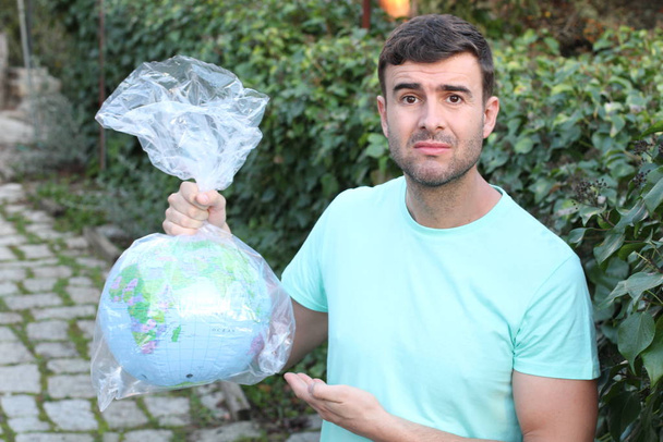 Triste homme portant la planète dans un sac en plastique
 - Photo, image