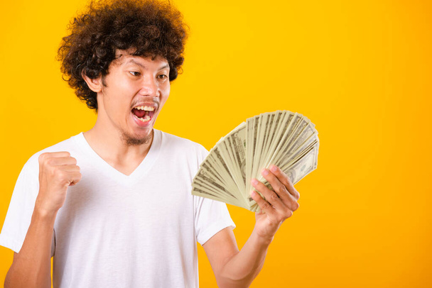 Asian handsome man with curly hair holding fans of money dollar  - Fotoğraf, Görsel
