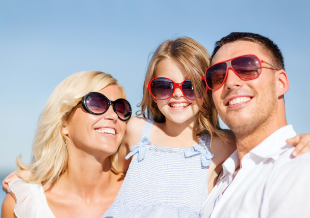 gelukkige familie met blauwe hemel - Foto, afbeelding