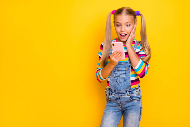 Omg new followers. Crazy energetic kid addicted blogger use smartphone read social media news impressed scream wear striped sweater jumper denim jeans isolated bright shine color background - Photo, image