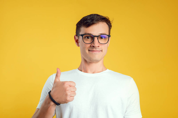 guy shows a thumb on a yellow background - Photo, Image