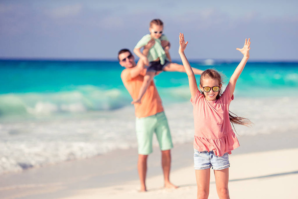 Батько і діти насолоджуються пляжним літнім відпочинком
 - Фото, зображення