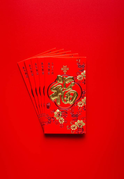 A red Chinese flyer with gold decorations and Chinese signs - Фото, зображення