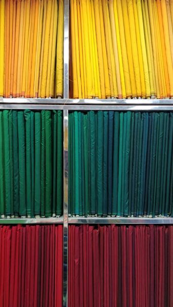 Vertical closeup shot of lists of colorful textiles on the shelves - Foto, immagini