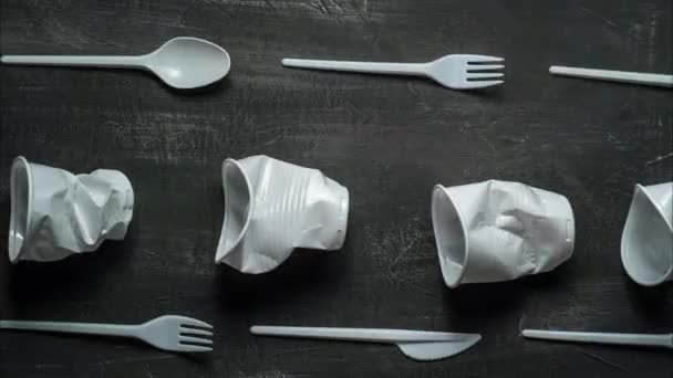 plastic problem concept, stop motion animation, place for text, white plastic dishes move on black background - Πλάνα, βίντεο