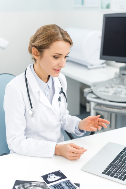 професійний жіночий лікар, що працює на ноутбуці в клініці з ультразвуковими скануваннями
 - Фото, зображення