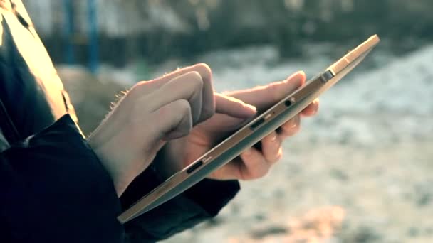 Girl flips through photos on a tablet close-up - Materiał filmowy, wideo