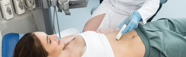панорамный снимок врача, осматривающего желудок молодой пациентки с помощью ультразвукового сканирования в клинике
  - Фото, изображение