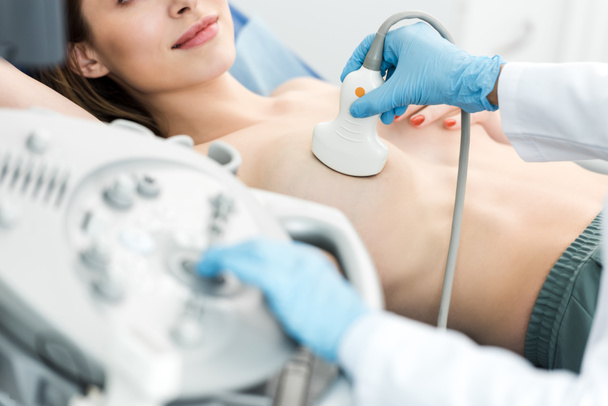 vista ritagliata del medico che effettua l'esame del seno per il paziente utilizzando scanner ad ultrasuoni
 - Foto, immagini