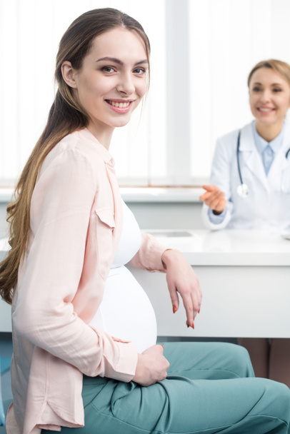 heureuse femme enceinte ayant une consultation avec gynécologue en clinique
 - Photo, image
