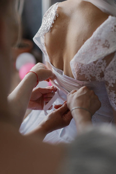 A young bride buttoned wedding dress. Happy wedding day. - Foto, Imagem