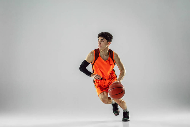 Young basketball player training isolated on white studio background - Foto, Imagen