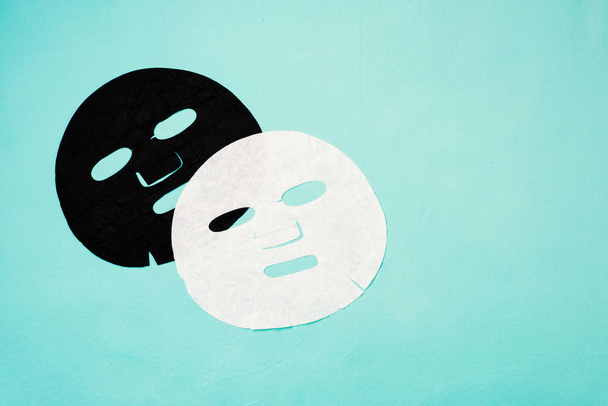 Zwart-wit gelaatsmaskers op een blauwe achtergrond - Foto, afbeelding