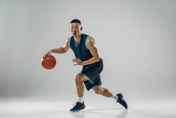 Young basketball player training isolated on white studio background - Fotografie, Obrázek