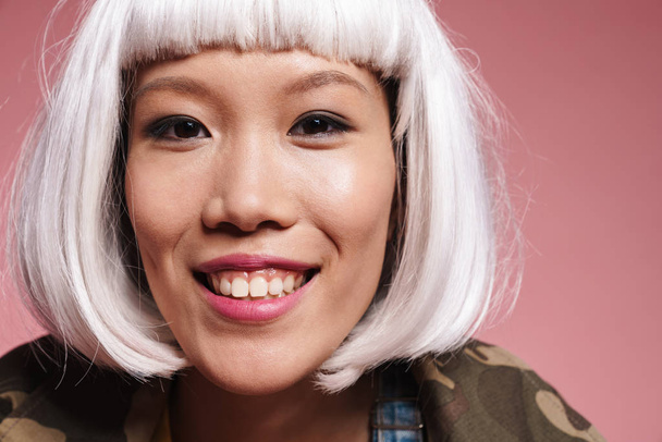 Image closeup of positive asian girl wearing white wig smiling a - Zdjęcie, obraz