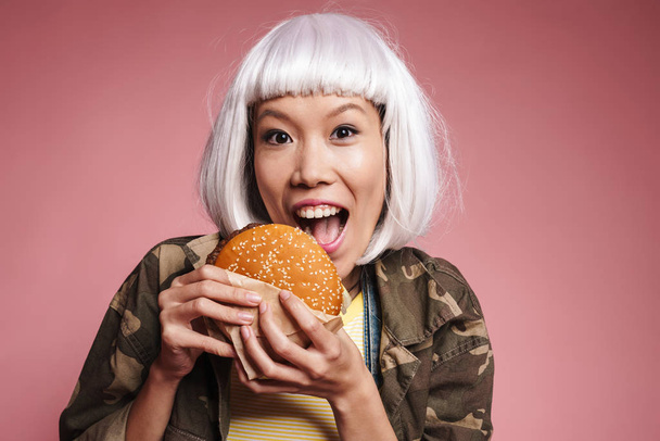 Image of young asian girl in white wig having fun and eating big - Photo, image