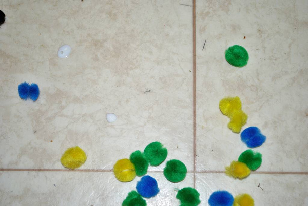 Разноцветные хлопчатобумажные помпоны, клей, клеевые палочки, строительная бумага и ножницы, покрывающие линолеум во время ремесел
 - Фото, изображение