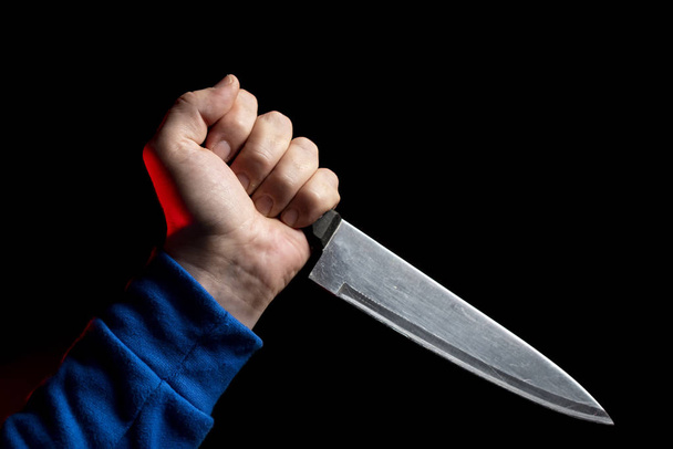 Кухонный нож в мужской руке привезли для забастовки. Крупный план на черном фоне
 - Фото, изображение