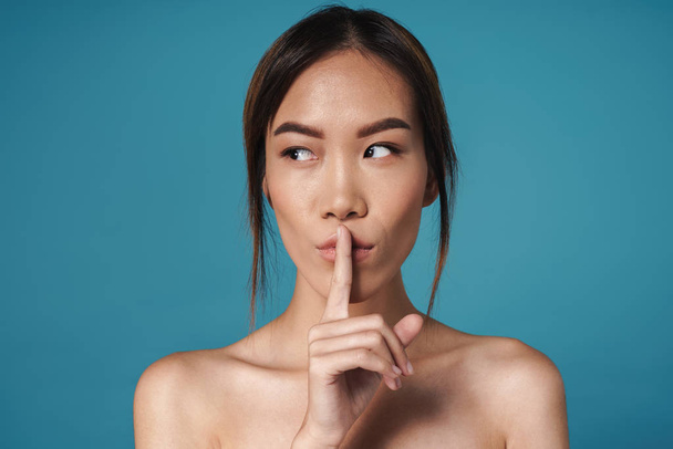 Woman posing naked showing silence gesture. - Photo, Image