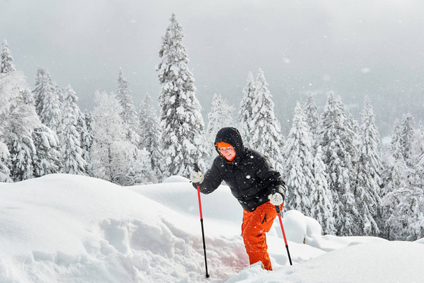 femme randonnée dans la forêt de montagne d'hiver lors d'une chute de neige
 - Photo, image