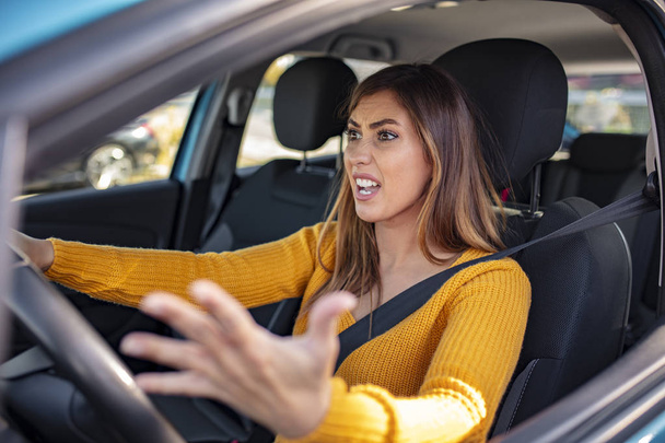 displeased woman driving the car and shouting at someone. Closeup portrait displeased angry pissed off aggressive woman driving car, shouting at someone, hands up in air isolated traffic background.  - Foto, Bild