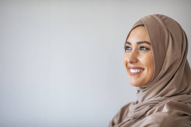 Portrait of pretty young asian muslim woman in head scarf smile. Portrait closeup of muslim prayer woman 20s in hijab smiling isolated over gray background.  - Valokuva, kuva