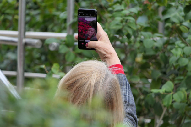 Woman taking selfie in a beautiful tropical orangire. - Photo, Image
