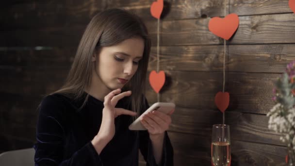 Дівчина зі склянкою шампанського посміхається і друкує на смартфоні
 - Кадри, відео