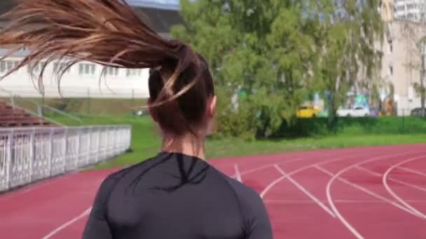 Mujer delgada corriendo en pista de carreras bajo el sol
 - Metraje, vídeo