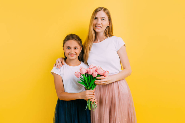 mother and daughter, a little girl gives her mother a bouquet of flowers - Φωτογραφία, εικόνα
