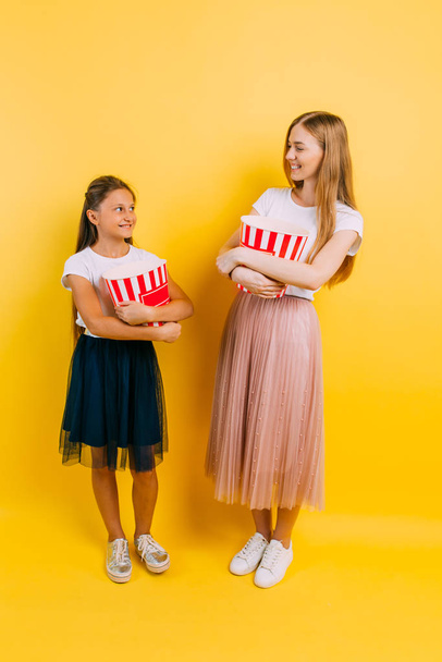 Happy mother and daughter with popcorn in their hands - Foto, afbeelding