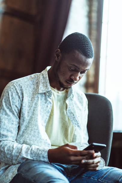 Young Black Guy Chats In Phone Sitting In Cozy Office - Φωτογραφία, εικόνα